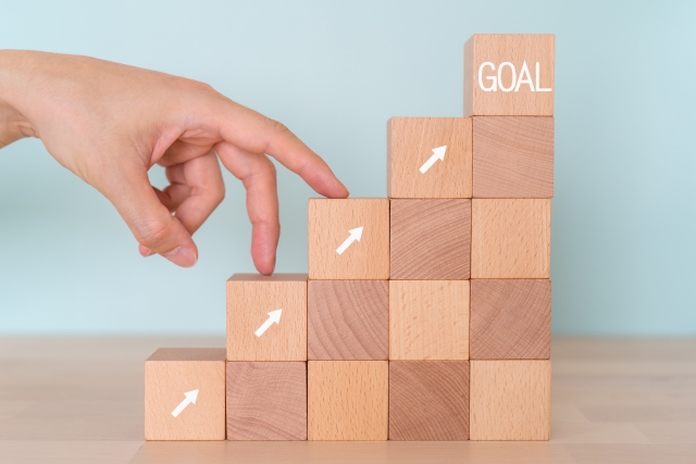 目標に向かって進むブロックと手を示した図