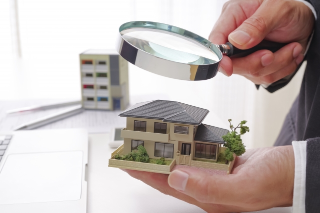 家のモデルを拡大鏡で調べる様子を示した図