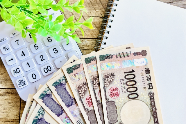 お金、電卓、ノートを並べた図