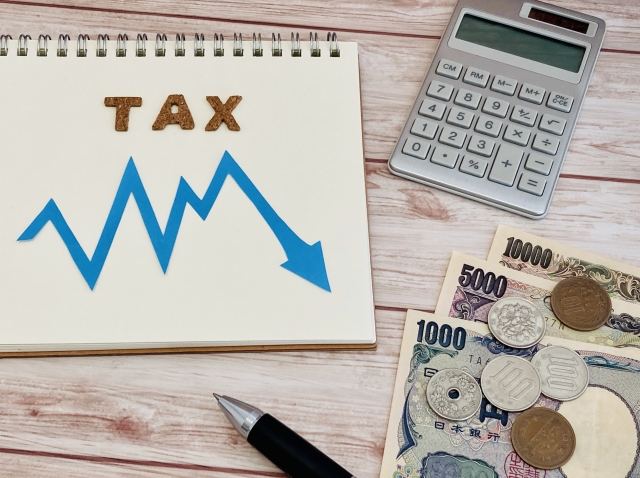 税金の減少を示すグラフとお金を示した図